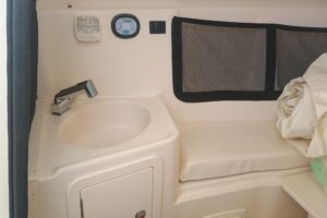 Grady-White Canyon 456 helm station with dual Garmin displays, stainless steel wheel, and forward visibility through hardtop.