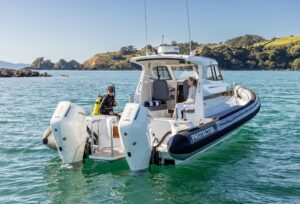 2025 Protector 380 Targa helm station with dual Garmin displays, steering wheel, and throttle controls overlooking the bow.