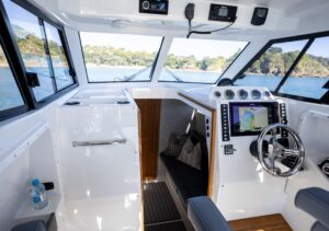 2025 Protector 380 Targa helm station with dual Garmin displays, steering wheel, and throttle controls overlooking the bow.