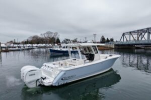 2025 Robalo R300 center console helm station with dual Garmin displays, steering wheel, and throttle controls overlooking ...