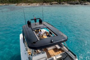 2026 Beneteau Grand Trawler 63 salon with upholstered seating, large windows, and teak accents.
