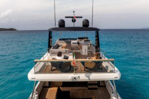 Beneteau Grand Trawler 63 helm station with dual Garmin displays and stainless steel wheel in pilothouse.