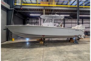 2026 Jupiter 32 center console fishing boat with hardtop and outboard engines shown in profile on the water.