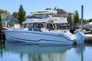 Wellcraft 38 T-Top center console helm station with dual Garmin displays, stainless steel wheel, and overhead hardtop prot...