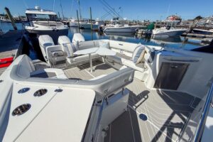 Wellcraft 38 T-Top helm station with dual Garmin displays, center console steering, and overhead T-top hardtop structure.